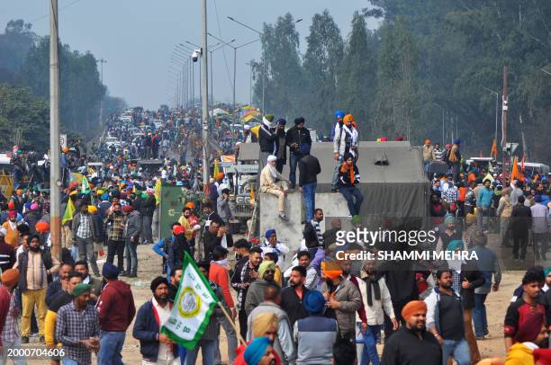 Farmers gather along a highway blocked by police as they try to march towards India's capital during a protest demanding minimum crop prices, at...