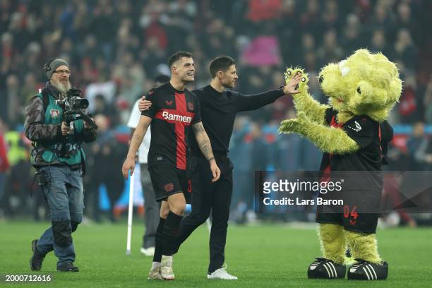 Granit Xhaka, Xabi Alonso and Brian the Lion celebrate following the team's victory during the Bundesliga match between Bayer 04 Leverkusen and FC...