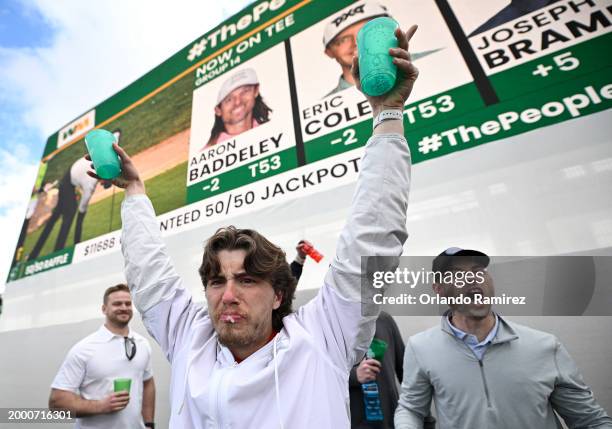 Fans celebrate on the 16th green during the continuation of the second round of the WM Phoenix Open at TPC Scottsdale on February 10, 2024 in...