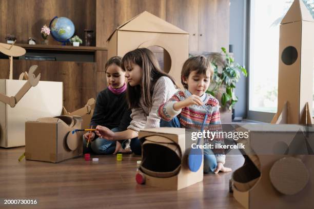 children doing home activity at home, they are painting their space helmets made of cardboard. - rpg maker stock pictures, royalty-free photos & images