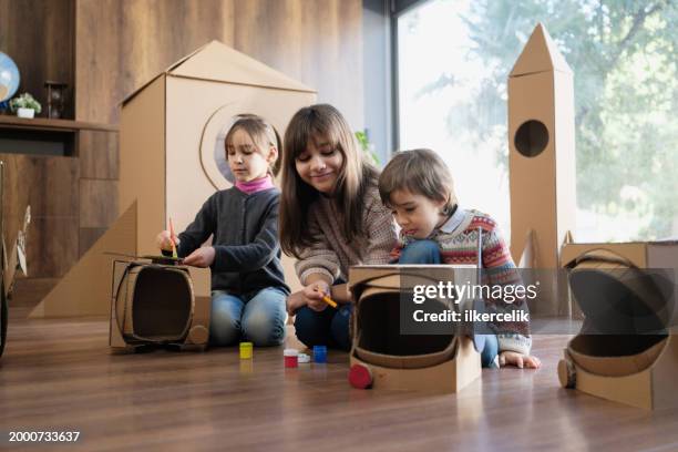 children doing home activity at home, they are painting their space helmets made of cardboard. - rpg maker stock pictures, royalty-free photos & images