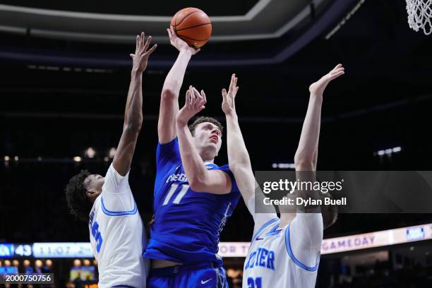 Ryan Kalkbrenner of the Creighton Blue Jays attempts a shot while being guarded by Dailyn Swain and Saša Ciani of the Xavier Musketeers in the second...