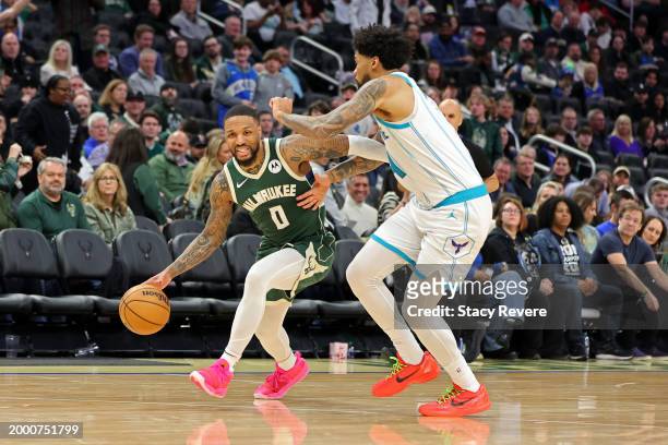 Damian Lillard of the Milwaukee Bucks is defended by Nick Richards of the Charlotte Hornets during a game at Fiserv Forum on February 09, 2024 in...