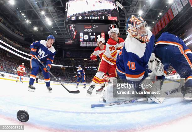 Andrei Kuzmenko of the Calgary Flames watches a second period shot by Simon Holmstrom get past Semyon Varlamov of the New York Islanders at UBS Arena...