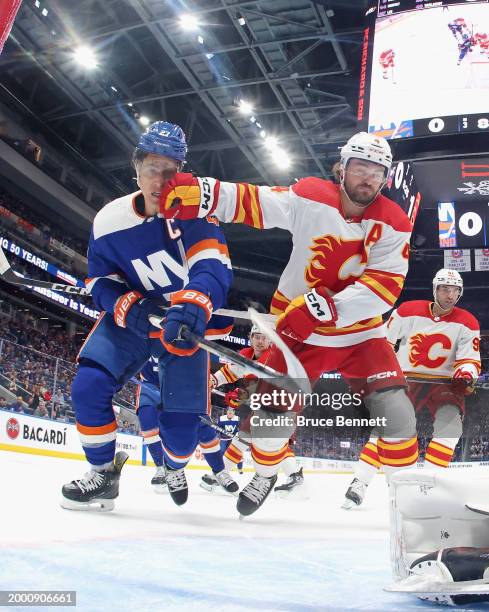 Rasmus Andersson of the Calgary Flames holds back Anders Lee of the New York Islanders during the second period at UBS Arena on February 10, 2024 in...
