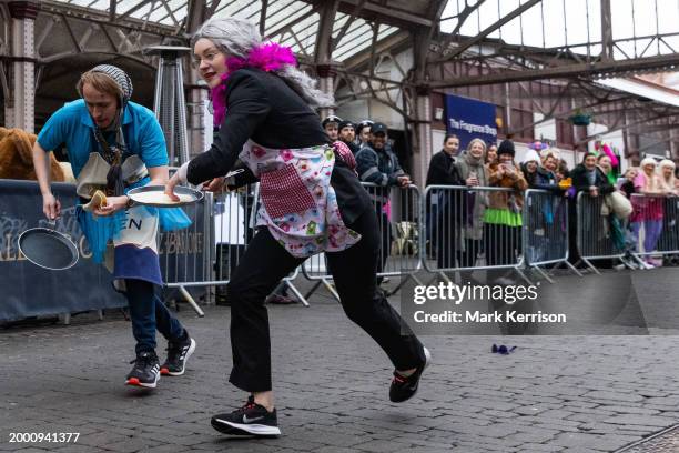 Competitors wearing fancy dress take part on Shrove Tuesday in the Windsor, Eton and Ascot Partnership Charity Pancake Race on 13th February 2024 in...