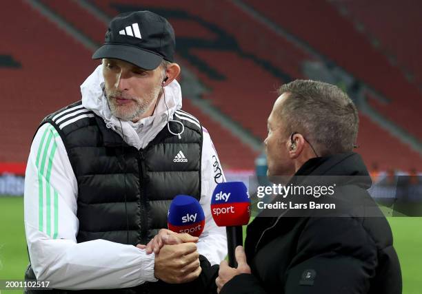 Thomas Tuchel, Head Coach of Bayern Munich, speaks to Lothar Matthaus following the team's defeat during the Bundesliga match between Bayer 04...