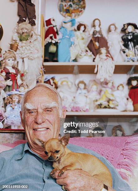 elderly man with pet chihuahua and doll collection, portrait - collection stock-fotos und bilder