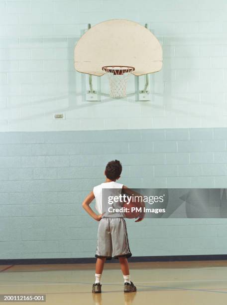 boy (8-10) holding basketball, looking at hoop, rear view - basket ball 個照片及圖片檔