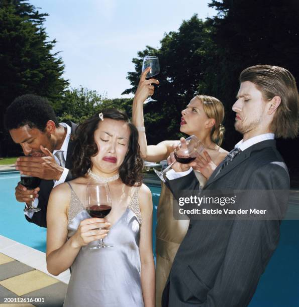 four young people pulling faces whilst tasting red wine - jury loisirs photos et images de collection