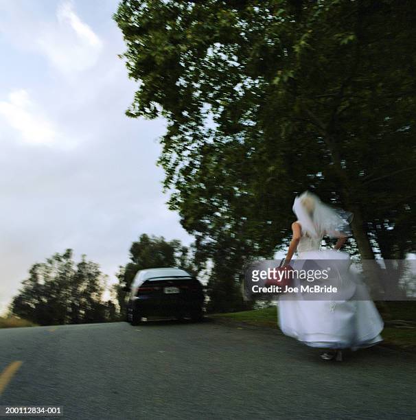bride carrying gas can, running toward stalled car, rear view - novia fotografías e imágenes de stock