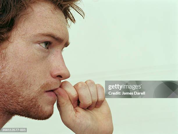 young man biting thumb nail, side view, close-up - nail biting stock pictures, royalty-free photos & images