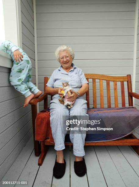 grandmother sitting on balcony, granddaughter (2-4) leaning on railing - old stuffed toy stock pictures, royalty-free photos & images