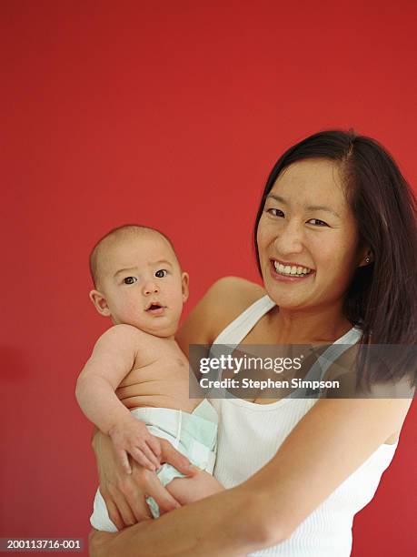 mother holding baby boy (4-6 months), portrait - family portrait studio stock pictures, royalty-free photos & images