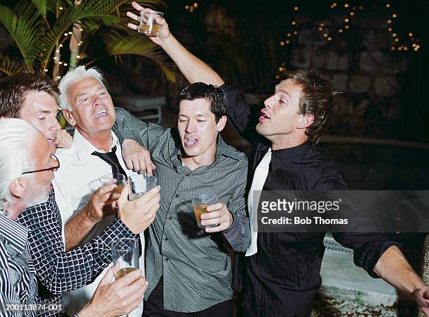 group of men raising toast outdoors, night - festa di addio al celibato foto e immagini stock