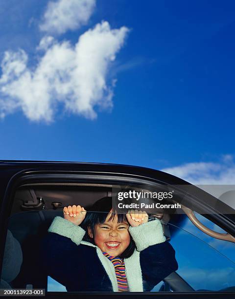 girl (4-6) looking out car window, smiling, portrait - girl side view stock-fotos und bilder