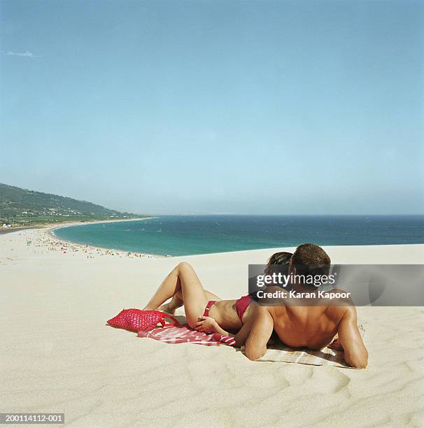 spain, andalucia, tarifa, young couple lying on beach - lying on back photos et images de collection