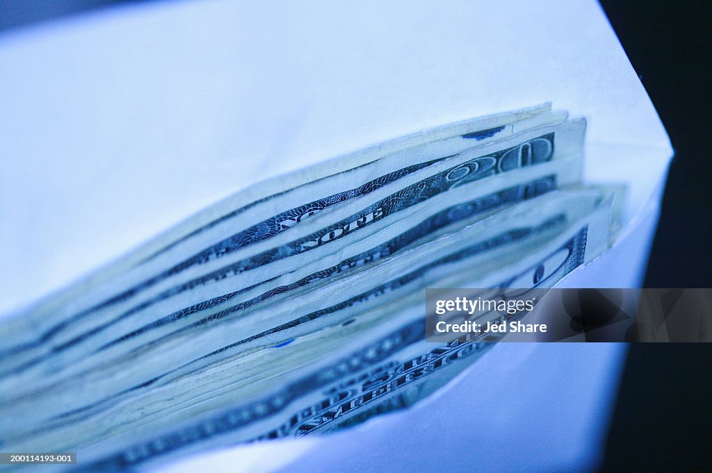 Envelope filled with US paper currency, close-up (Digital Enhancement)