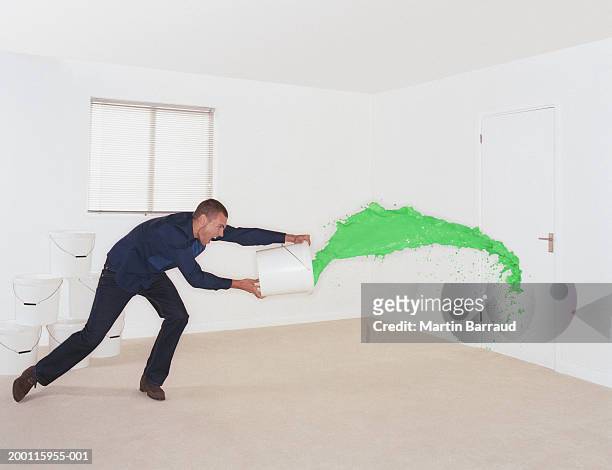man throwing bucket of green paint at door - throwing foto e immagini stock
