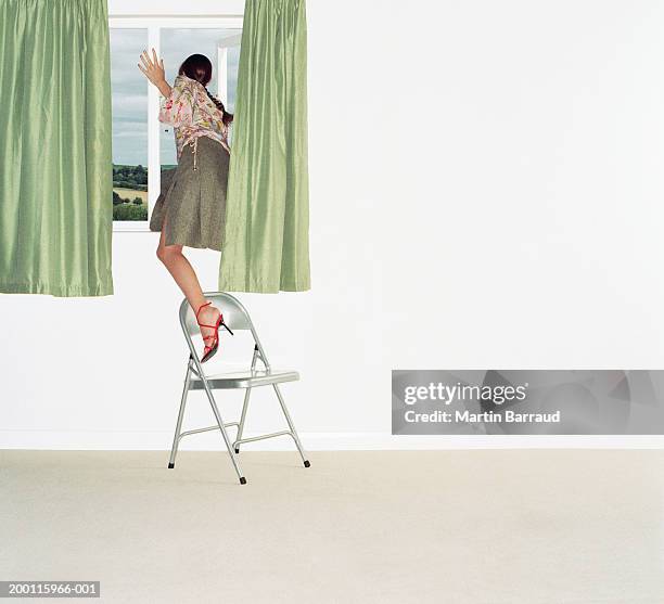 woman climbing out of window, rear view - woman climb stock pictures, royalty-free photos & images