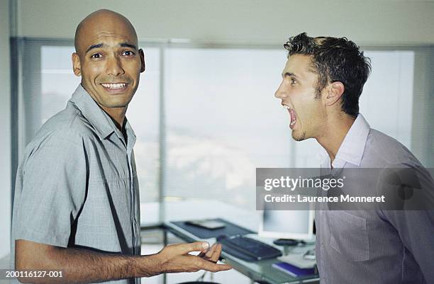man being shouted at by work colleague, portrait - kommunikationsproblem stock-fotos und bilder