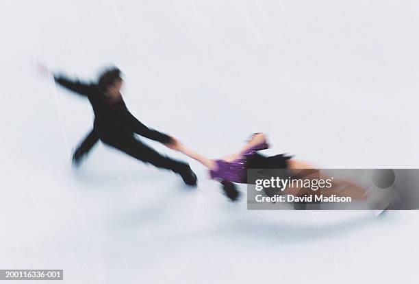couple figure skating on ice, elevated view (blurred motion) - figure skating couple stock pictures, royalty-free photos & images