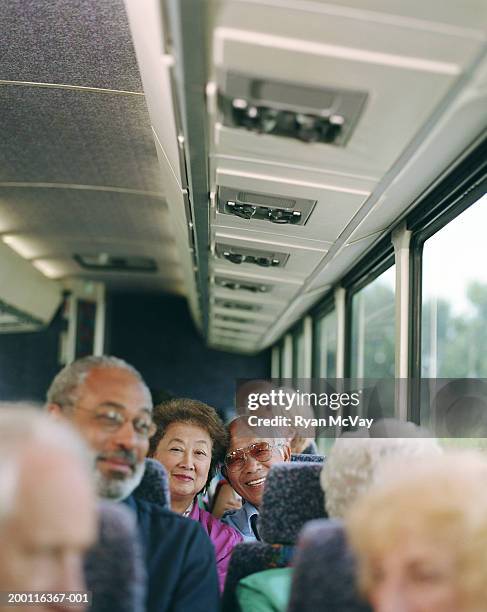 elderly couple on coach bus, smiling, portrait - car journey photos et images de collection