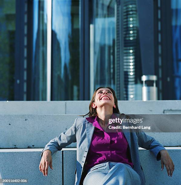 young businesswoman outdoors, head thrown back, smiling - purple suit stock pictures, royalty-free photos & images