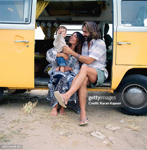 parents with baby girl (12-15 months) sitting in camper van doorway - baby shoes stock-fotos und bilder