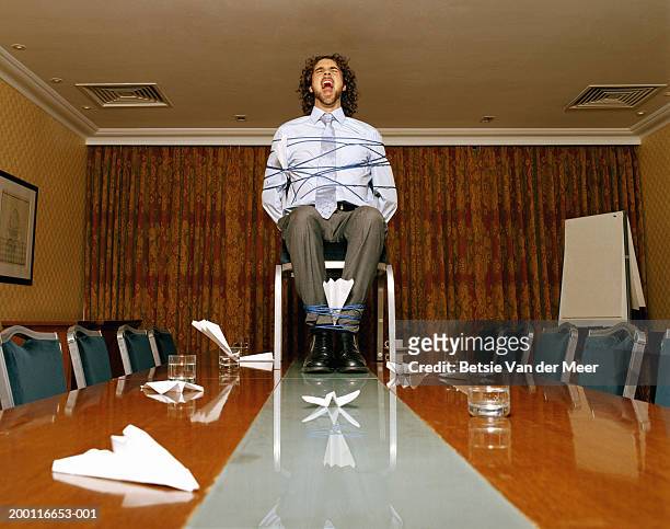 businessman on conference room table bound to chair, screaming - guy tied up stock pictures, royalty-free photos & images