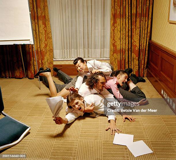 four executives fighting on conference room floor, man grasping papers - rivalry stock pictures, royalty-free photos & images