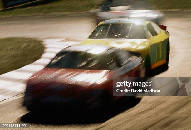 stock cars racing on track (blurred motion) - stock car racing stock-fotos und bilder