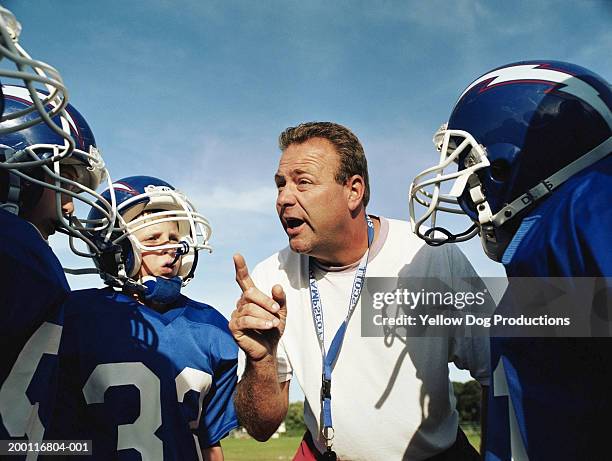 coach talking to pee wee football team - little league football stock pictures, royalty-free photos & images
