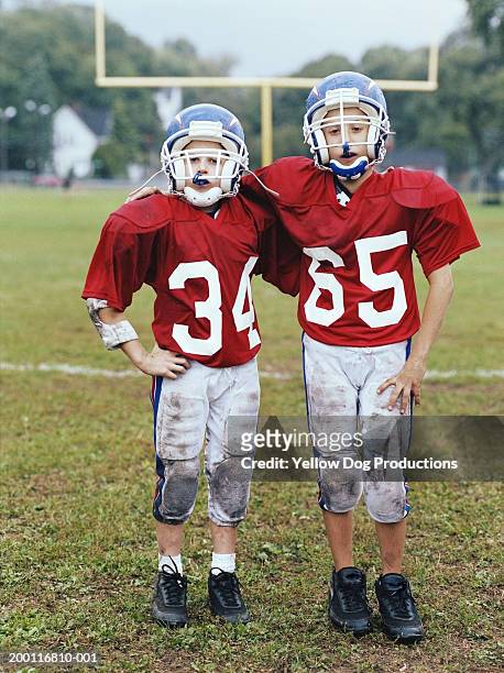 two boys (10-12) in football uniforms on field, portrait - american football uniform stock pictures, royalty-free photos & images