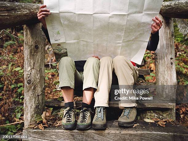 two female hikers sitting on wooden steps, looking at map - hiking boot stock pictures, royalty-free photos & images