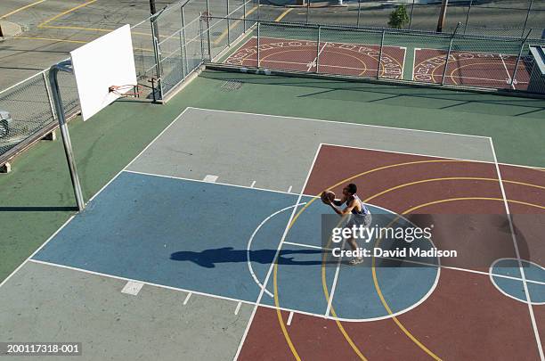 man practicing free throws on outdoor basketball court, elevated view - atirar ao cesto imagens e fotografias de stock