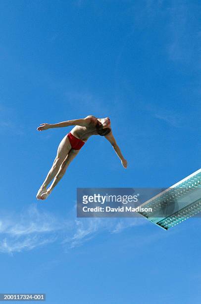 young male diver in midair - young men in speedos 個照片及圖片檔