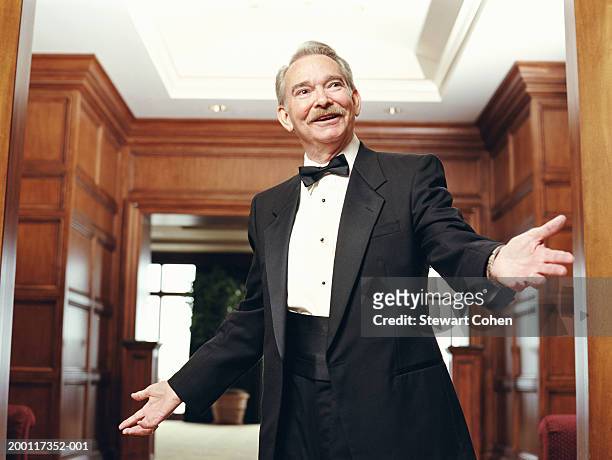 senior man wearing tuxedo, reaching out hand - smoking activity stock-fotos und bilder