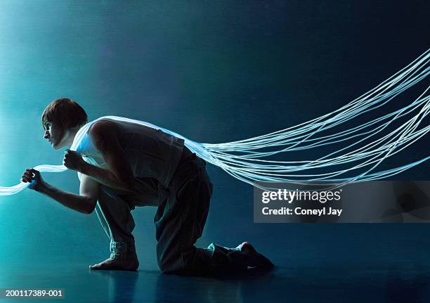 young man crouching with fibre optic cables over shoulder - heavy load stock pictures, royalty-free photos & images