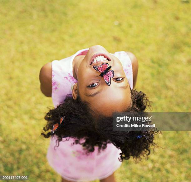girl (8-10) with butterfly on nose, hanging head upside down, portrait - girl upside down stock pictures, royalty-free photos & images