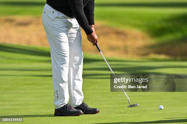 Detail of the TaylorMade Sun Day Red pants and shoes worn by Tiger Woods as he putts during practice for The Genesis Invitational at Riviera Country...