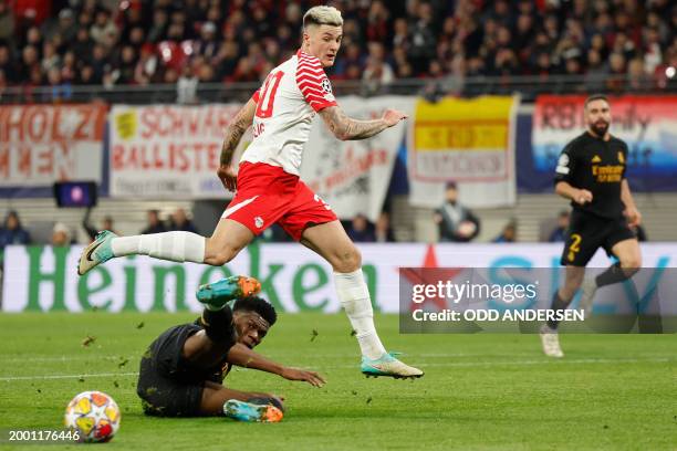 Leipzig's Slovenian forward Benjamin Sesko jumps over Real Madrid's French defender Aurelien Tchouameni during the UEFA Champions League Round of 16,...