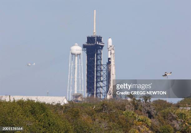 Pelicans glide above the Turning Basin past a SpaceX Falcon 9 rocket, ready for the Intuitive Machines' Nova-C moon lander mission at launch pad...