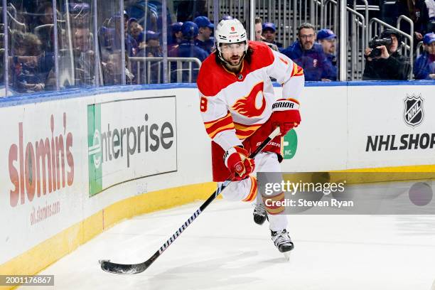 Chris Tanev of the Calgary Flames carries the puck against the New York Islanders at UBS Arena on February 10, 2024 in Elmont, New York.