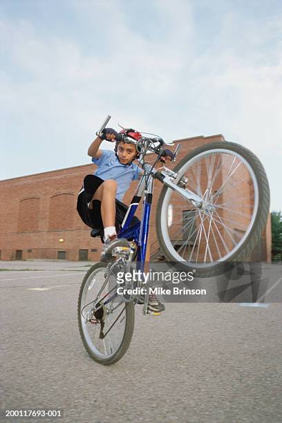 boy (10-12) doing a wheelie, portrait - wheelie stock pictures, royalty-free photos & images