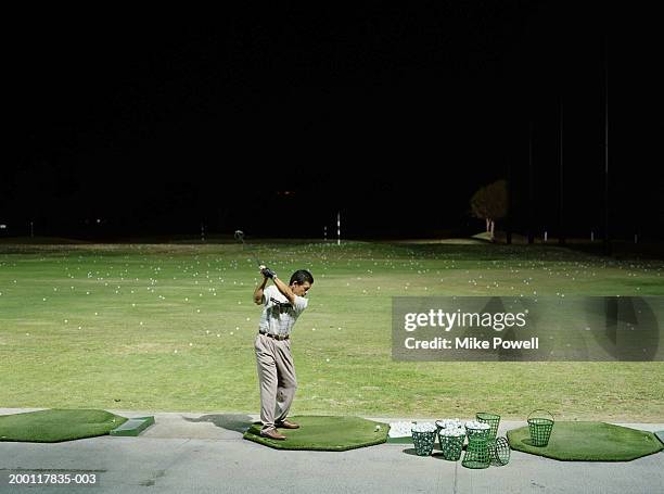 homem a praticar golfe intervalo de condução à noite - praticando imagens e fotografias de stock