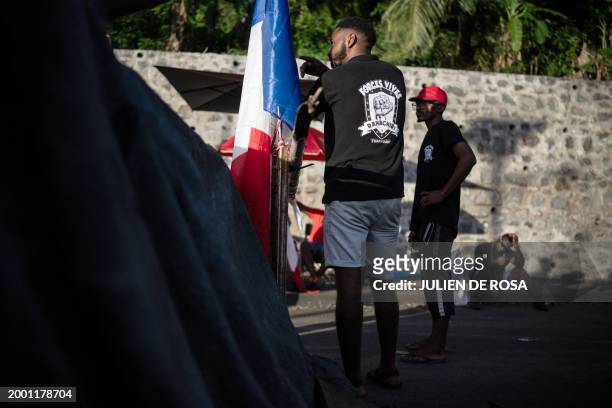Members of the Forces Vives collective stand at a roadblock set up by residents of surrounding villages to protest against living conditions and...
