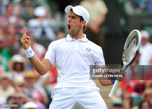Serbian player Novak Djokovic reacts as he plays with French player Michael Llodra during the men's single at the Wimbledon Tennis Championships at...