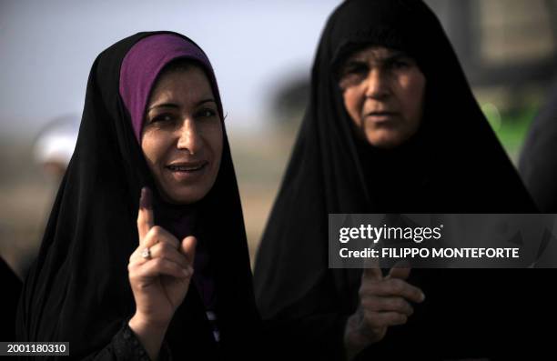 Iraqi women hold up their ink-stained fingers as they exit a polling station in the eastern town of Khanaqin, in Diyala province near Iraq's border...