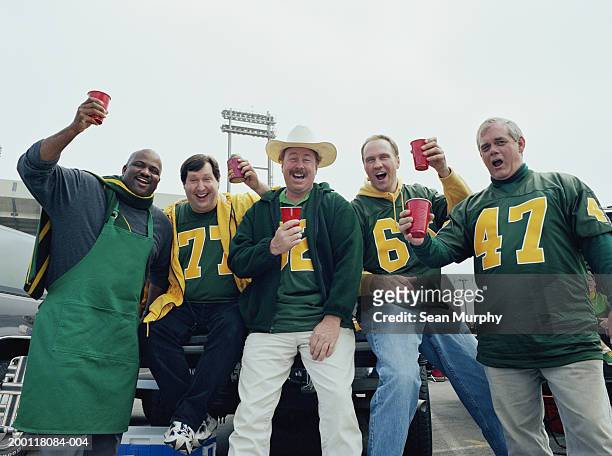 men holding red cups at tailgate party in stadium parking lot - 30 39 years stock pictures, royalty-free photos & images